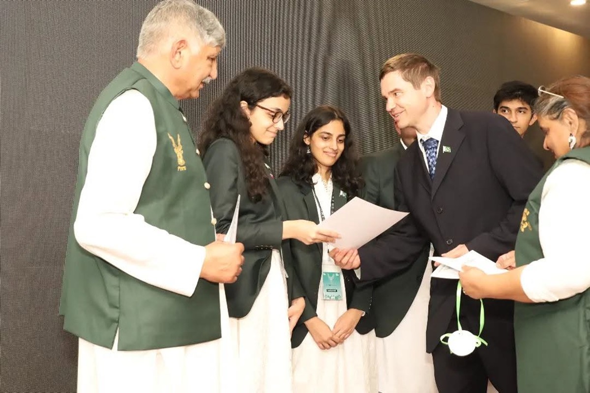 Team members receive documents from an international official
